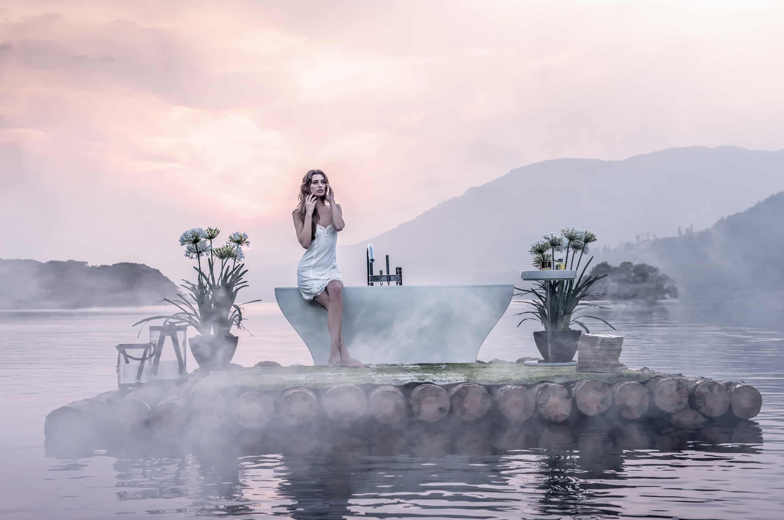 The Bathrooms Company's artistic photoshoot features a woman sitting on a bath that is floating on a raft on the lake.